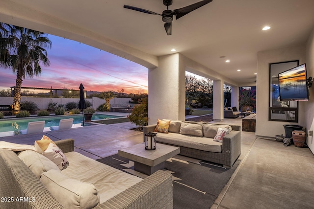 patio terrace at dusk with ceiling fan, an outdoor living space, and a fenced in pool