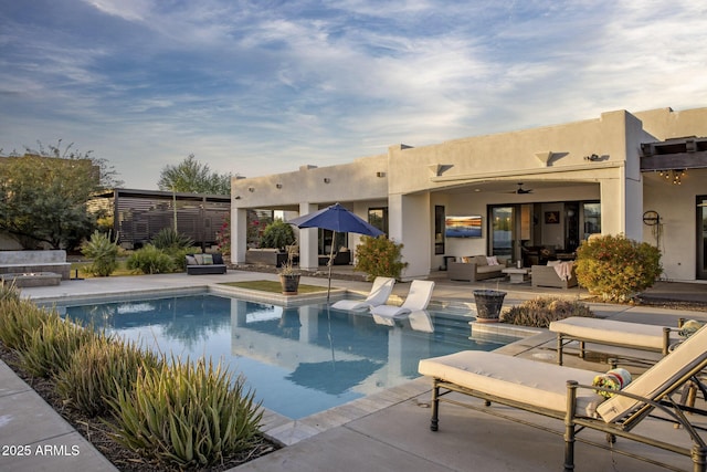 view of swimming pool with outdoor lounge area, ceiling fan, and a patio area