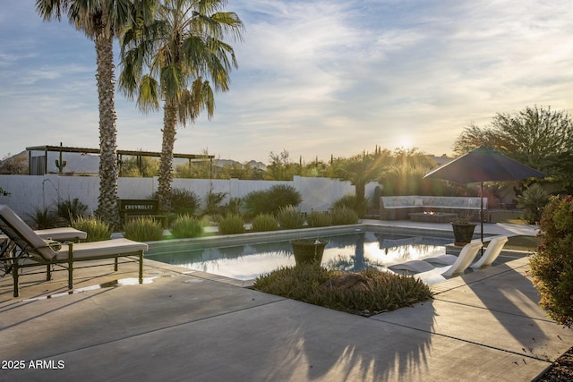 pool at dusk featuring a patio