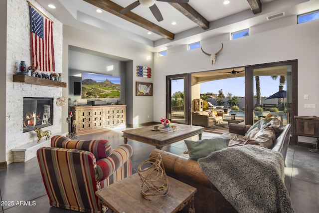 living room with ceiling fan, concrete flooring, a high ceiling, a stone fireplace, and beamed ceiling