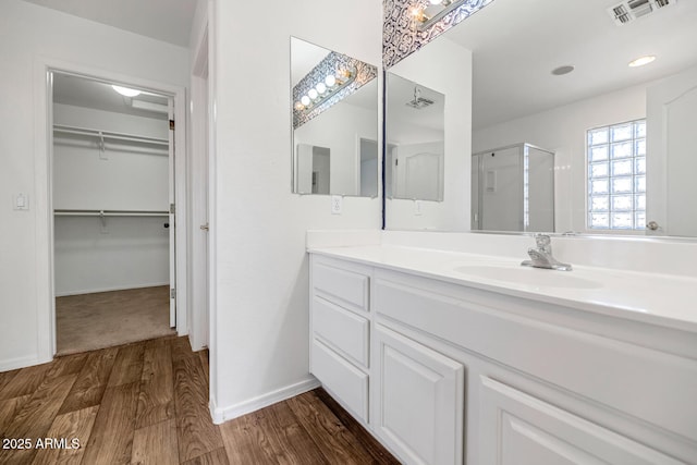 5787 W Barbara Ave, Glendale, AZ 85302 - full bathroom with wood finished floors, a shower stall, vanity, a walk in closet, and baseboards