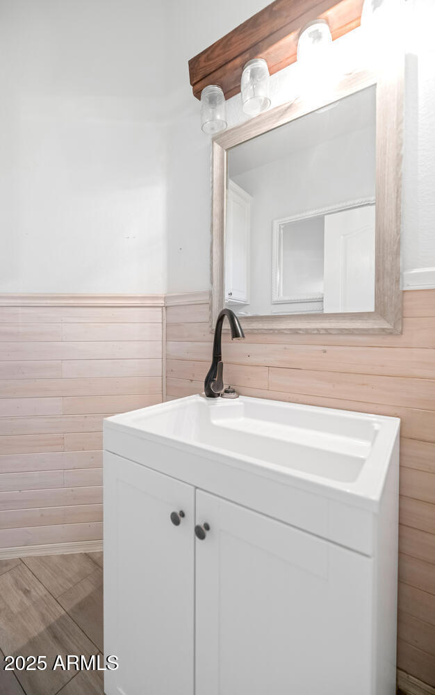 5787 W Barbara Ave, Glendale, AZ 85302 - bathroom featuring wooden walls, vanity, and wainscoting