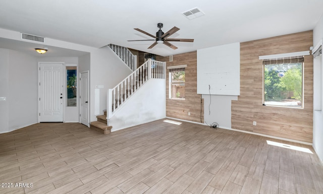 5787 W Barbara Ave, Glendale, AZ 85302 - unfurnished living room featuring stairs, a ceiling fan, healthy amount of natural light, wood walls, and wood finished floors