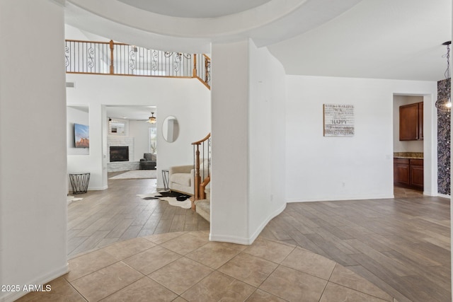 11142 E Ravenna Ave, Mesa, AZ 85212 - entrance foyer with a glass covered fireplace, ceiling fan, wood finished floors, and stairway