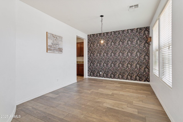 11142 E Ravenna Ave, Mesa, AZ 85212 - unfurnished dining area with wallpapered walls, wood finished floors, baseboards, healthy amount of natural light, and a chandelier