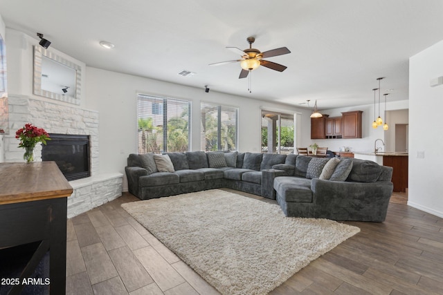 11142 E Ravenna Ave, Mesa, AZ 85212 - living area with ceiling fan, dark wood-type flooring, and a stone fireplace