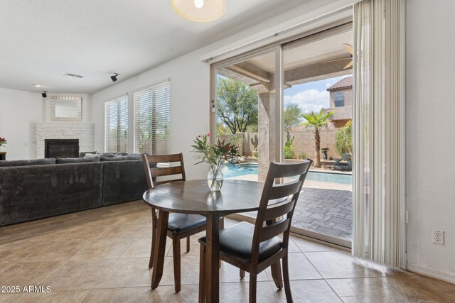 11142 E Ravenna Ave, Mesa, AZ 85212 - dining room with a glass covered fireplace and light tile patterned floors