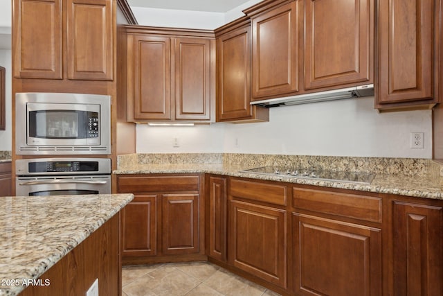 11142 E Ravenna Ave, Mesa, AZ 85212 - kitchen featuring appliances with stainless steel finishes, under cabinet range hood, brown cabinets, and light stone countertops
