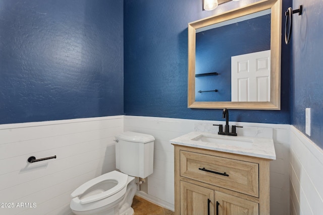 11142 E Ravenna Ave, Mesa, AZ 85212 - half bathroom featuring toilet, vanity, and a wainscoted wall