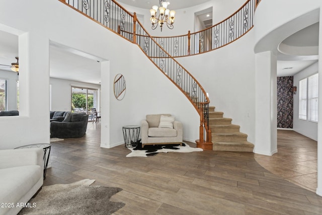 11142 E Ravenna Ave, Mesa, AZ 85212 - staircase featuring wood finished floors, a towering ceiling, baseboards, and a chandelier