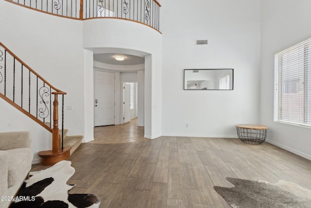 11142 E Ravenna Ave, Mesa, AZ 85212 - entrance foyer featuring a high ceiling, wood finished floors, plenty of natural light, arched walkways, and stairway