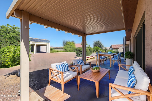 view of patio / terrace featuring a garage, an outbuilding, and outdoor lounge area