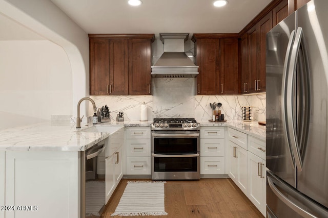 kitchen with white cabinets, custom range hood, kitchen peninsula, and appliances with stainless steel finishes