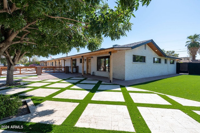 view of front of property with a front yard and a patio area