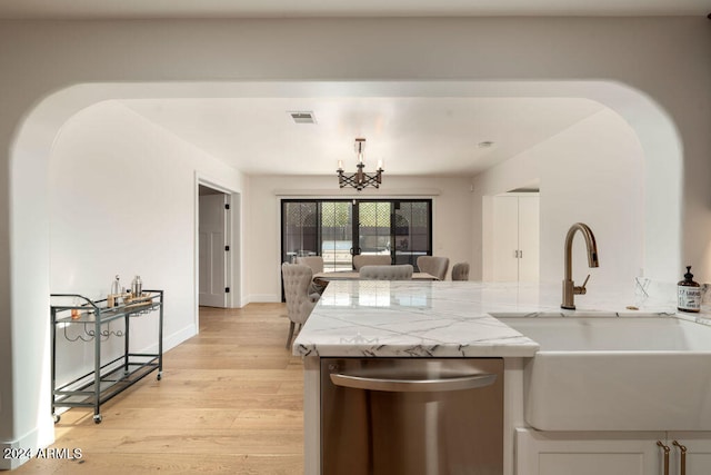 kitchen featuring light stone countertops, sink, light hardwood / wood-style floors, dishwasher, and a chandelier