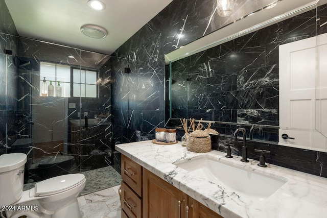 bathroom with a shower, vanity, toilet, and tile walls