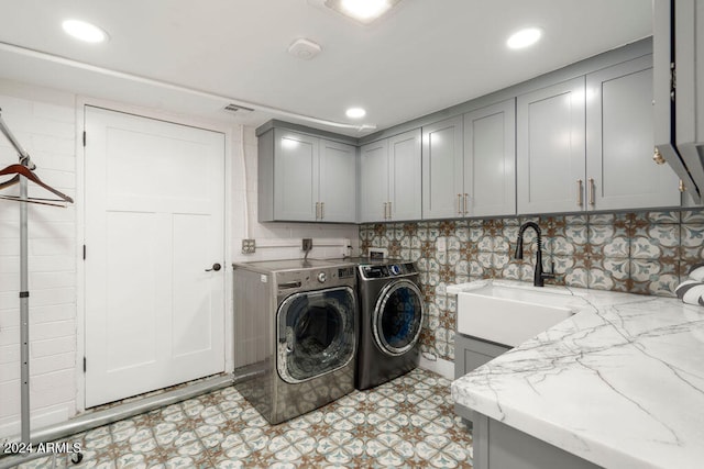 laundry area with separate washer and dryer, cabinets, and sink