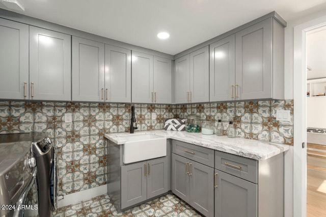 clothes washing area with sink, cabinets, independent washer and dryer, and light hardwood / wood-style floors