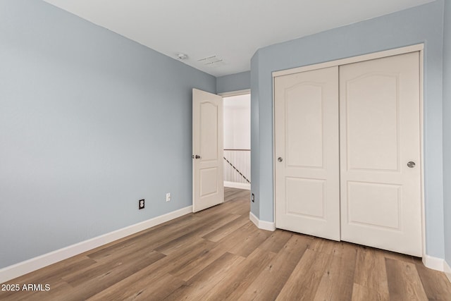 unfurnished bedroom featuring light wood-type flooring and a closet