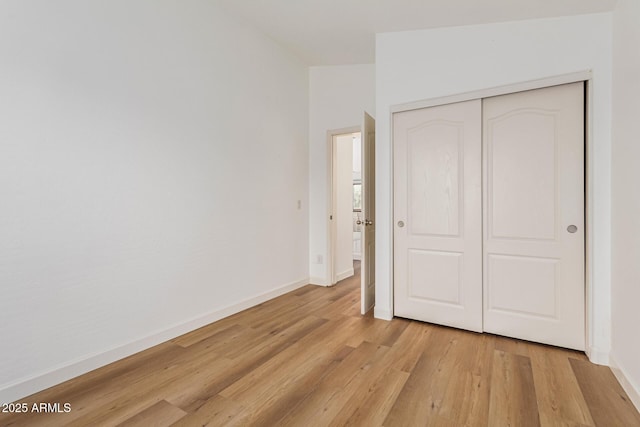 unfurnished bedroom featuring light hardwood / wood-style flooring and a closet
