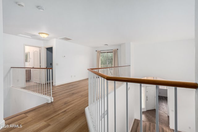 corridor with hardwood / wood-style flooring