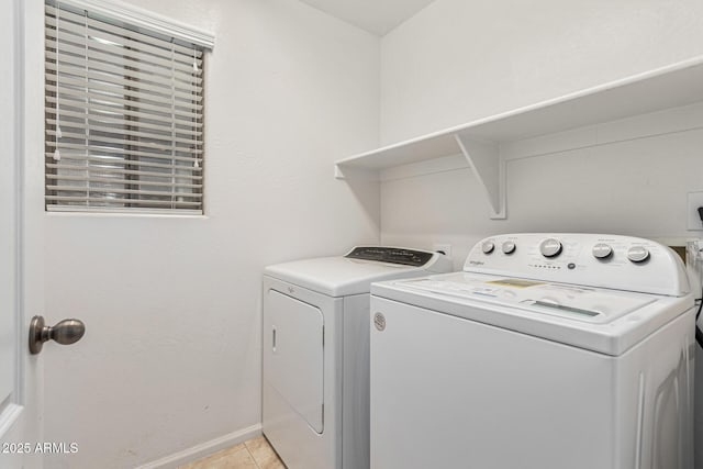 laundry area with washing machine and clothes dryer and light tile patterned floors
