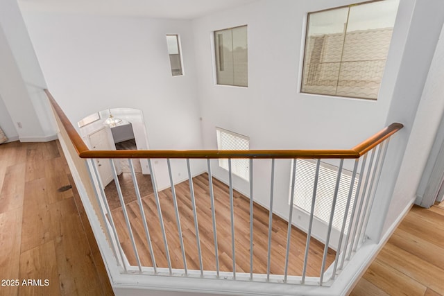 stairs with a chandelier and hardwood / wood-style flooring