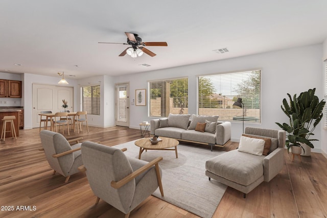 living room featuring ceiling fan and light hardwood / wood-style flooring