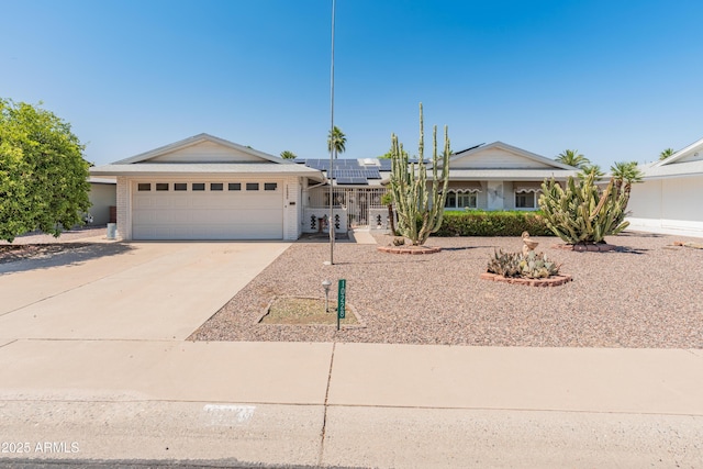 10228 W Concord Ave, Sun City, AZ 85351 - ranch-style home featuring roof mounted solar panels, an attached garage, concrete driveway, and brick siding