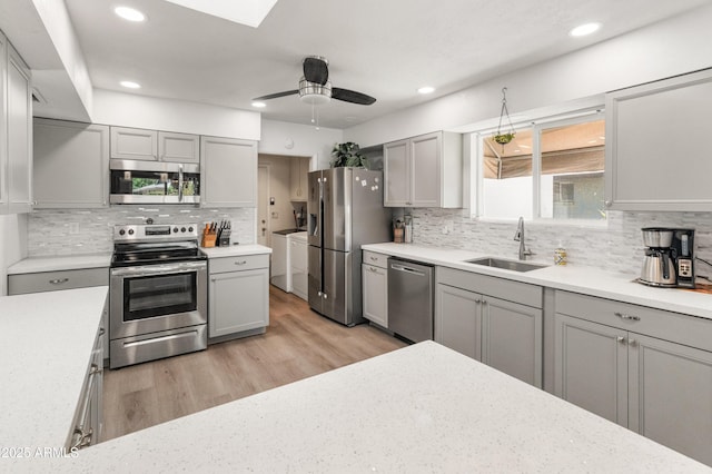 10228 W Concord Ave, Sun City, AZ 85351 - kitchen featuring stainless steel appliances, a sink, washer and dryer, gray cabinetry, and recessed lighting