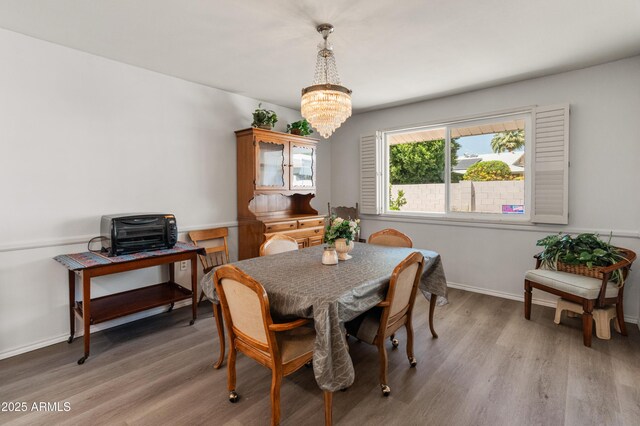 10228 W Concord Ave, Sun City, AZ 85351 - dining space with a chandelier, light wood-style floors, and baseboards