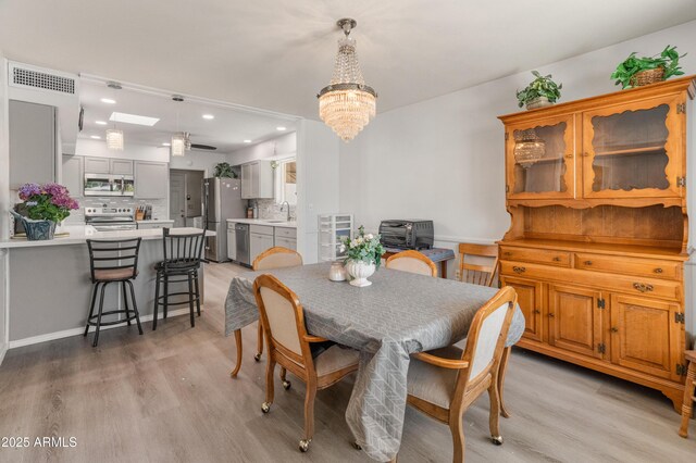 10228 W Concord Ave, Sun City, AZ 85351 - dining space featuring light wood-style flooring, a chandelier, and recessed lighting