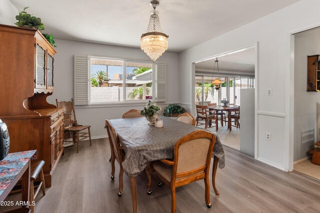 10228 W Concord Ave, Sun City, AZ 85351 - dining area with light wood-style flooring, plenty of natural light, a chandelier, and baseboards