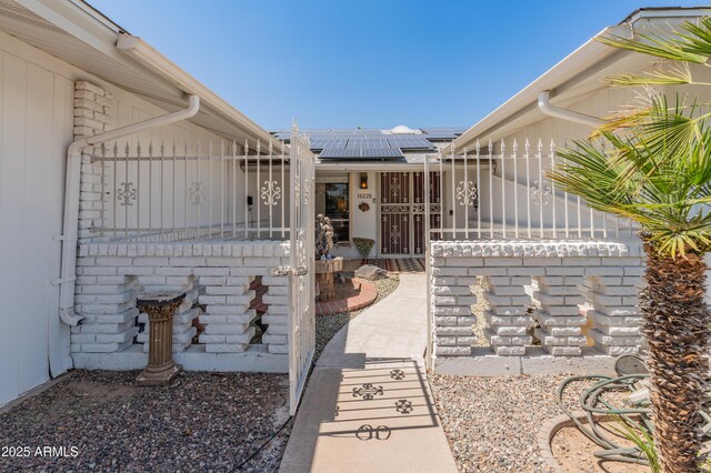 10228 W Concord Ave, Sun City, AZ 85351 - exterior space with solar panels, fence, a gate, and board and batten siding