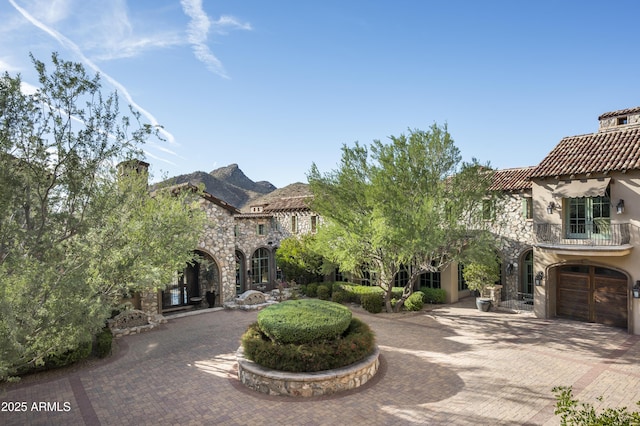 exterior space with a mountain view, a balcony, and a garage