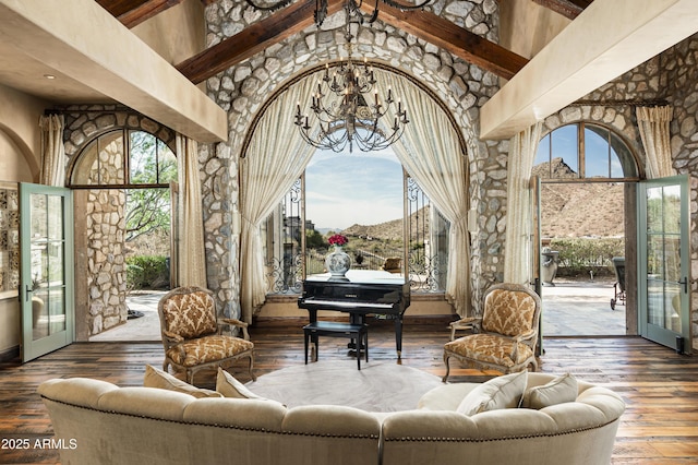 sunroom / solarium featuring french doors, lofted ceiling with beams, and an inviting chandelier