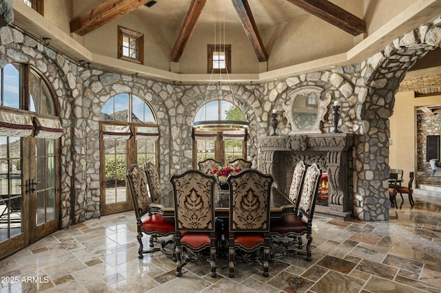 dining space featuring beamed ceiling, french doors, and a towering ceiling