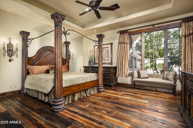 bedroom with a tray ceiling, ceiling fan, and dark hardwood / wood-style flooring