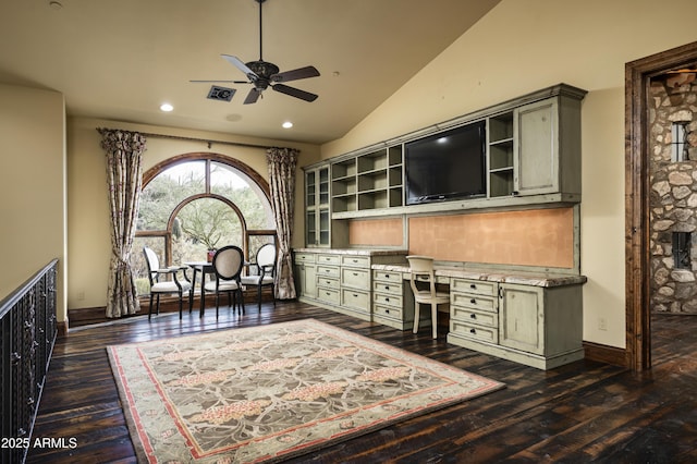 office space featuring ceiling fan, high vaulted ceiling, built in desk, and dark hardwood / wood-style floors