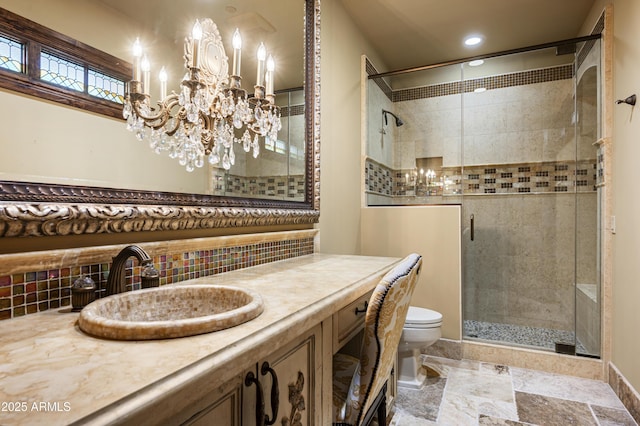 bathroom with decorative backsplash, vanity, a shower with door, an inviting chandelier, and toilet