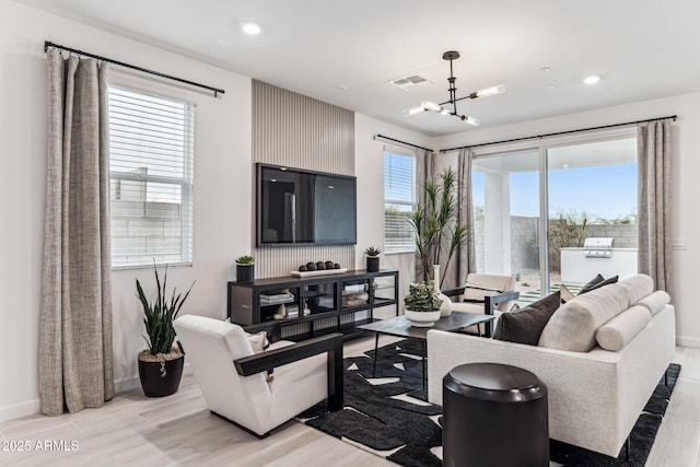 living room featuring a chandelier and light hardwood / wood-style floors