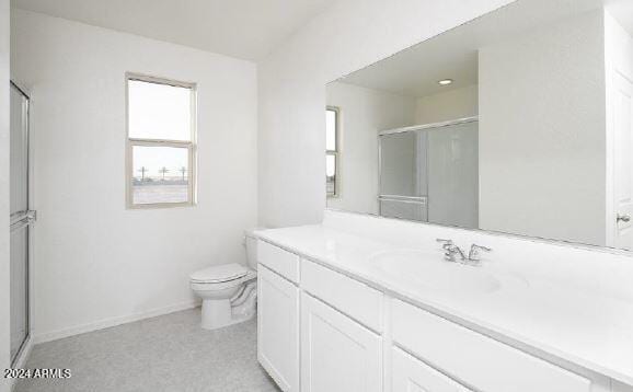 bathroom featuring vanity, toilet, and a shower with door