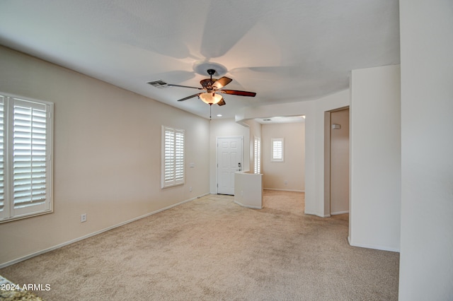 carpeted spare room with ceiling fan