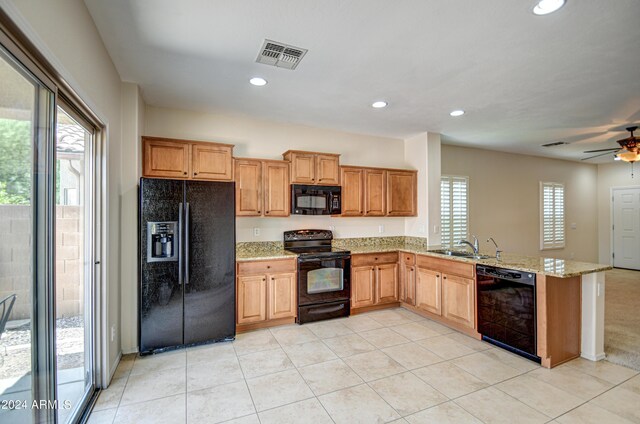 kitchen featuring light tile patterned flooring, light stone countertops, ceiling fan, and black appliances