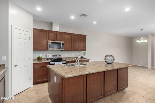 kitchen featuring a kitchen island with sink, an inviting chandelier, sink, decorative light fixtures, and stainless steel appliances