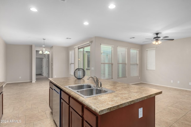 kitchen with dishwasher, a kitchen island with sink, ceiling fan with notable chandelier, sink, and hanging light fixtures