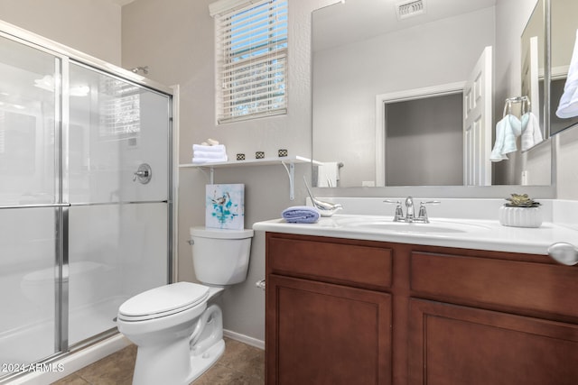 bathroom with tile patterned flooring, vanity, an enclosed shower, and toilet