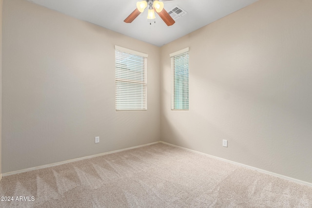 empty room featuring ceiling fan and carpet