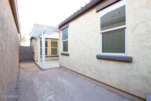 view of side of home featuring a pergola and a patio