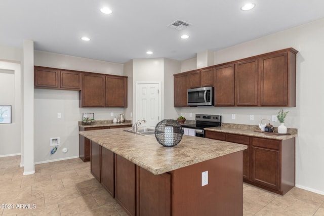 kitchen with sink, a kitchen island with sink, and appliances with stainless steel finishes